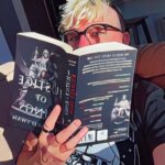 Josiah Frost Co-Founder of Paperbound Realms peeking from behind a book with reading glasses.